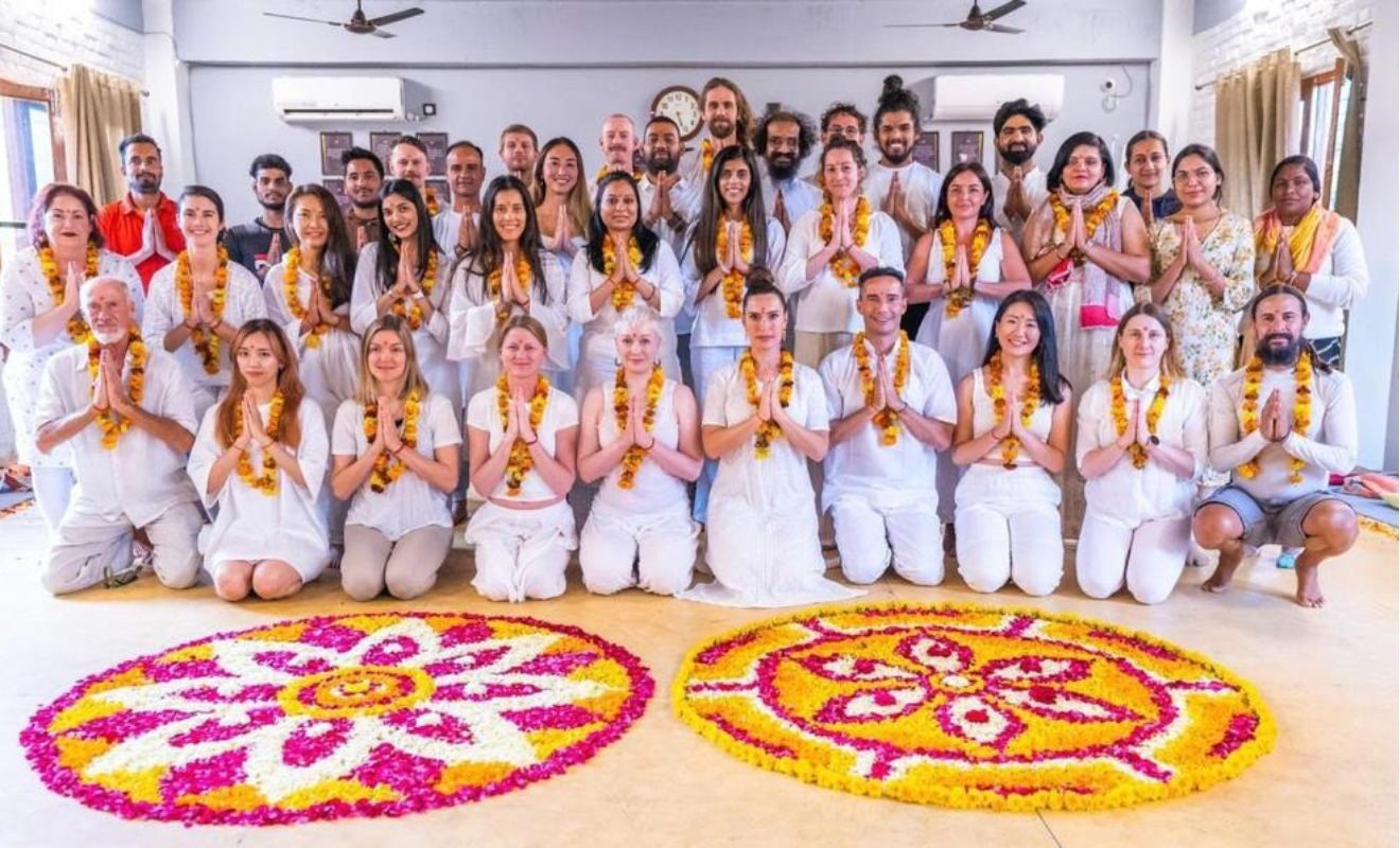 Yoga students at Bali Yoga School dressed in white with flower malas during their yoga teacher training in Bali.