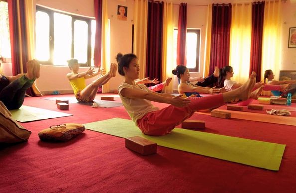 Yoga students in navasana (boat pose) during yoga teacher training in Rishikesh.