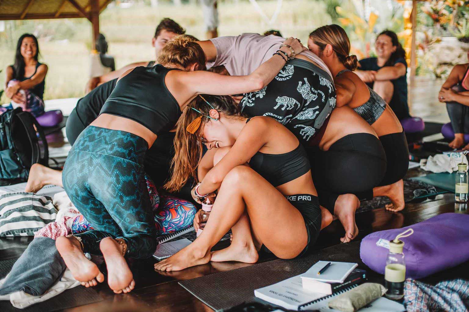 Yoga students in a group hug in the shala during their yoga teacher training in Bali with Yoga Union.