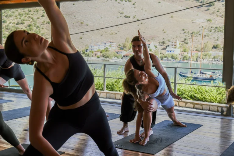 Aris from Alpha Yoga School adjusting a student during yoga class in Evia Island, Greece